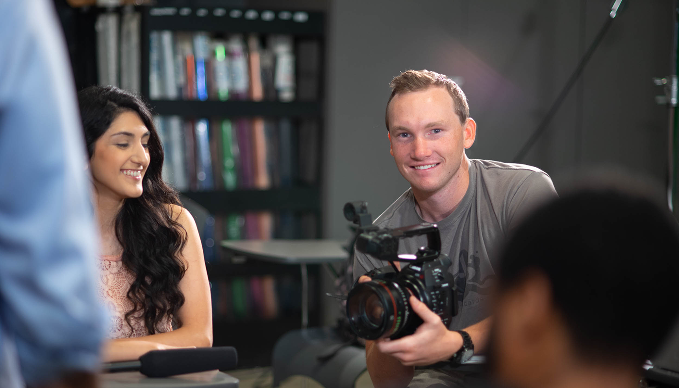 Film and Television student at SBCC holding a camera.